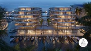 two apartment buildings with boats in a marina at night at Waterfront Porto Antico House in Genoa