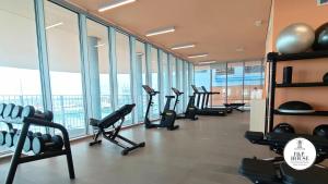 a gym with treadmills and ellipticals in a room with windows at Waterfront Porto Antico House in Genoa