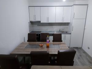 a kitchen with a table with chairs and a microwave at Prizren Apartament in Prizren