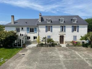 a large white house with a large driveway at Séjour champêtre à la ferme près de Pau in La Celle-sous-Gouzon