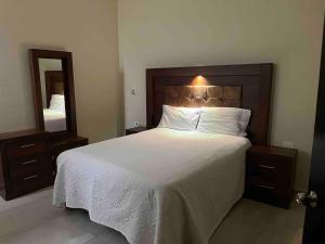a bedroom with a large bed and a large mirror at Bonito apartamento cerca de la zona comercial in Villa Hidalgo