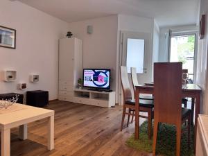 - un salon avec une table à manger et une télévision dans l'établissement Apartment Nera - Zell am See, à Zell am See
