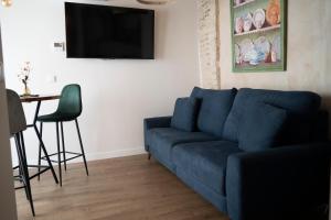 a living room with a blue couch and a table at Arena Centro Rooms&Suites in Seville