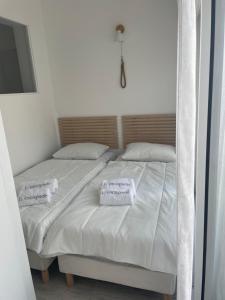a bedroom with two beds with white sheets and pillows at L'escapade in Saint-Tropez
