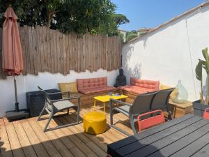 a patio with a couch and a table and chairs at L'escapade in Saint-Tropez
