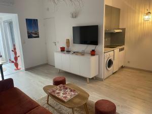 a living room with a tv and a washer and dryer at L'escapade in Saint-Tropez