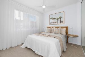 キングスクリフにあるDeluxe Beachfront Escapeのベッドと窓のある白い寝室
