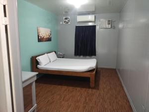 a small room with a bed with white sheets at Hope Pension House - Danao in Danao City