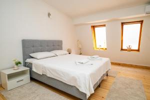ein Schlafzimmer mit einem großen Bett mit weißer Bettwäsche in der Unterkunft Quiet Apartments with FREE PARKING in Sarajevo