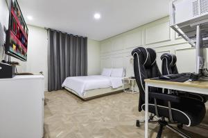 a hotel room with a bed and a desk with a computer at Film Hotel in Incheon
