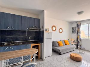 kuchnia i salon z kanapą i stołem w obiekcie Palm Garden Apartment w mieście Morro del Jable
