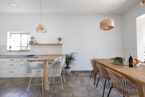 a kitchen with a wooden table and chairs at בגג העמק - וילה in HaZore‘im
