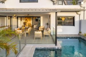 an open patio with a pool and a house at VILLA M - Entre mer montagne in Trois Bassins