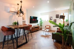 a living room with a table and chairs and a tv at Jungle Évasion, Épernay - Jacuzzi & Sauna in Épernay
