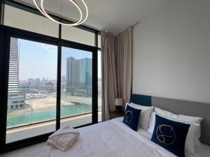 une chambre avec un grand lit avec une grande fenêtre dans l'établissement Elegant 3BDR Vista 1 Al Maryah, à Abu Dhabi
