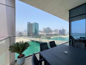 d'une table et de chaises sur un balcon avec vue sur la ville. dans l'établissement Elegant 3BDR Vista 1 Al Maryah, à Abu Dhabi