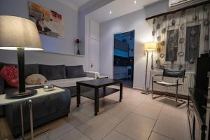 un salon avec un canapé et une table dans l'établissement Top-Floor Apt with Private Patio- Nea Ionia by ΜΡS, à Athènes