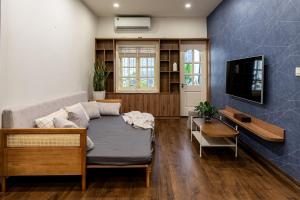 a living room with a couch and a tv at HanoianHearths - FamilyReunion- Projector- Bathtub in Hanoi