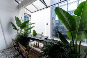a conservatory with a table and benches and plants at HanoianHearths - FamilyReunion- Projector- Bathtub in Hanoi