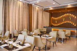a restaurant with tables and chairs and a bar at HHW Buddha lineage Sarnath Varanasi in Varanasi