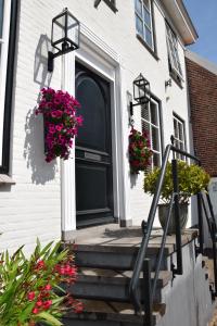 a black door on a white house with flowers at De Witte Gans in Ootmarsum