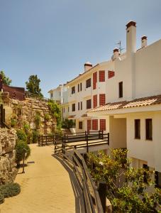 a walkway with a fence and some buildings at Green Haven Casares in Casares