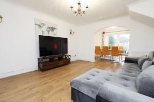 a living room with a couch and a flat screen tv at Kites House Long Stays Sleep 8 Free Parking and WI-FI in Bristol