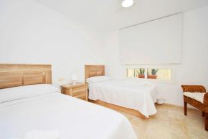 a bedroom with two beds and a chair and a window at Expoholidays - Centro Almerimar Puerto Deportivo in Almerimar
