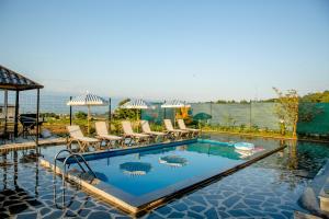 泰拉维Villa Vardi的配有躺椅和遮阳伞的游泳池