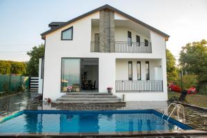 a house with a swimming pool in front of it at Villa Vardi in Telavi