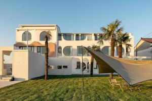 a hammock in front of a building with palm trees at Shanghai -Creek -Camping -BBQ -Parent-child- Homestay in Shanghai