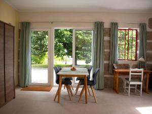 a dining room with a table and chairs and windows at Starbase18 lda Ecotourism in Fernão Joanes