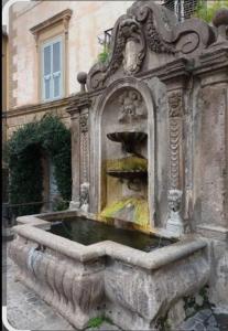 a stone fountain in front of a building at La Casa di Gioia in Tuscania +16 photos