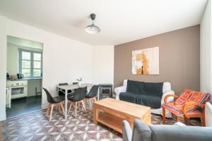 a living room with a couch and a table at La Brise de Mer - 10min de la Plage in Les Moitiers-dʼAllonne +4 photos