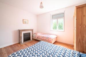 a bedroom with a bed and a fireplace at La Brise de Mer - 10min de la Plage in Les Moitiers-dʼAllonne