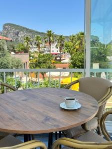 a coffee cup sitting on a wooden table on a balcony at MOY Beldibi Hotel in Antalya