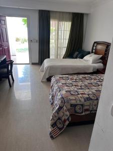 a bedroom with two beds and a door to a patio at Downtown,Delta sharm in Sharm El Sheikh +15 photos