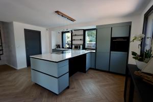 a kitchen with black cabinets and a white counter top at Les Suites in Camiers