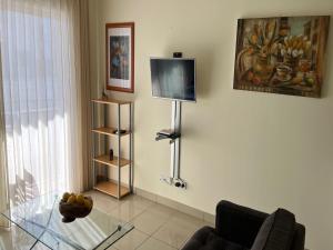 sala de estar con mesa de cristal y TV en Estartit Park 1-1, en Torroella de Montgrí