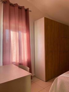a bedroom with a pink curtain and a cabinet at Villa Claudia - Appartamento B in Corazzello