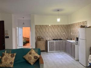 a living room with a couch and a kitchen at Maison salakta plage in Ksour Essaf