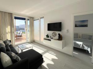 a living room with a couch and a television at Toni LuXx Suite Monte Golf in Mogán