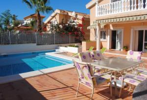 a patio with a table and chairs next to a swimming pool at Casa Aqua in Mazarrón