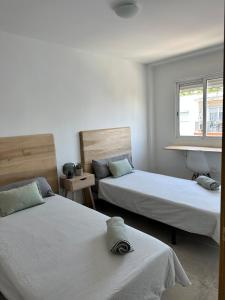 a bedroom with two beds and a window at Abadesa Apartments in Benetúser