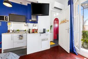 a kitchen with white cabinets and a tv on the wall at Hyper Center - Air conditioning - Balcony - Wifi - Tramway - Quiet in Nice