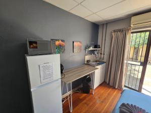 a room with a refrigerator and a desk in it at Stay at 126 in Bloemfontein