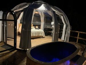 a tub in a gazebo on a deck at night at La bulle in Villexavier +7 photos
