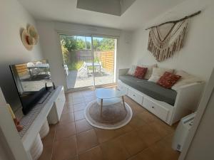 Una pequeña sala de estar con un sofá y una mesa. en Logement proche Aéroport Nantes, en Saint-Aignan-Grand-Lieu