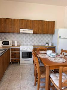 a kitchen with a table with chairs and a refrigerator at Sidirounta Village Apartment in Sidiroúnta +28 photos