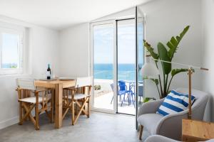 a dining room with a table and a view of the ocean at OUTPOST - Ocean Casitas in Azenhas do Mar